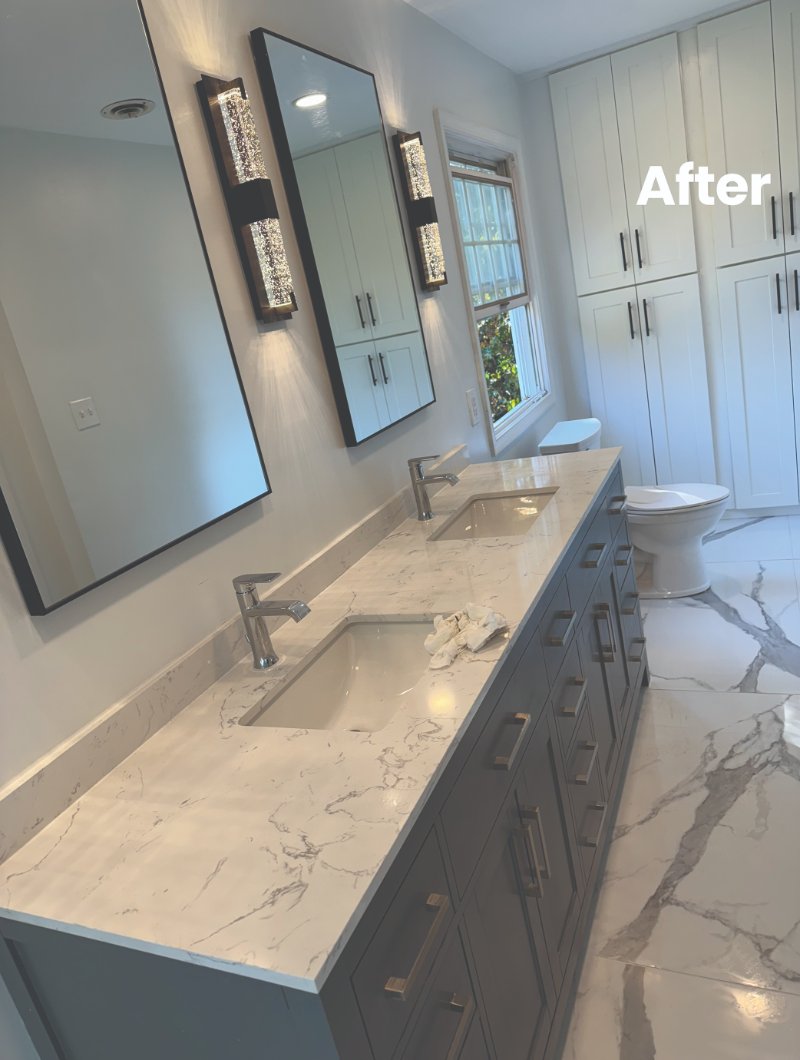 After picture of a newly renovated bathroom with white granite surfaces and large mirrors
