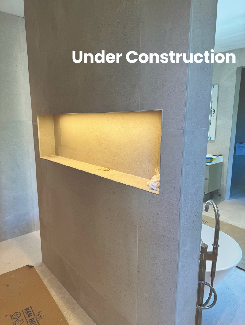 Bathroom renovation under construction with an indented wall shelf with recessed lighting