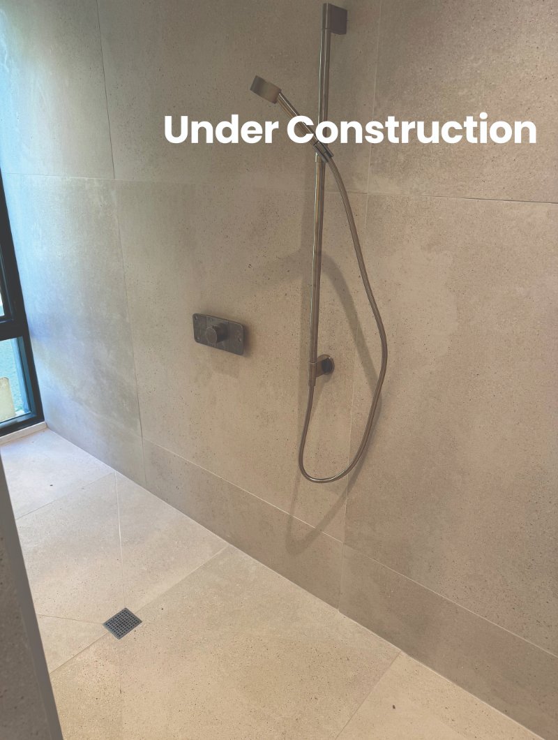 Bathroom renovation under construction with modern shower design and shower head